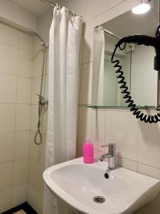 a bathroom with a sink and a pink soap dispenser at Firmeza 358 studios - street level in Porto