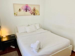 a white bed with a stuffed animal on it at Firmeza 358 studios - street level in Porto