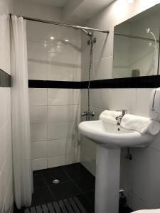 a white bathroom with a sink and a mirror at Firmeza 358 studios - street level in Porto