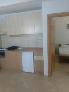 a kitchen with white cabinets and a white refrigerator at Villa Daniela Apartments in Nov Dojran