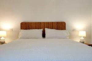 a bedroom with a large white bed with two lamps at Casa Ruggiero in Capri