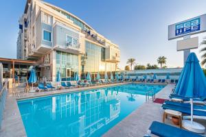 einen Pool in einem Hotel mit Stühlen und Sonnenschirmen in der Unterkunft Sealife Family Resort Hotel in Antalya