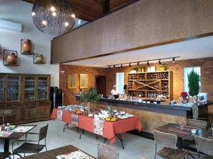 a dining room with a table and a bar at Hotel Vila Serrana in Sete Lagoas
