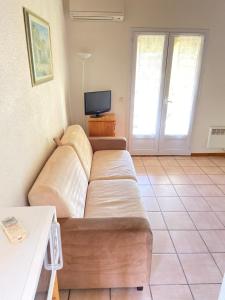 a living room with a couch and a tv at Domaine De La Bégude in Fayence