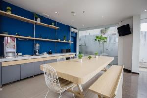 eine Küche mit einem Tisch und Stühlen sowie blauen Wänden in der Unterkunft Bobotel Gatot Subroto Medan in Medan
