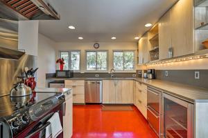 cocina grande con armarios de madera y suelo rojo en Modern Boise Vacation Rental with Yard Near Downtown, en Boise