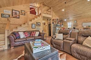 ein Wohnzimmer mit Ledermöbeln und einer Treppe in der Unterkunft Peaceful Family Cabin on 10 Acres with Game Room! in Heflin