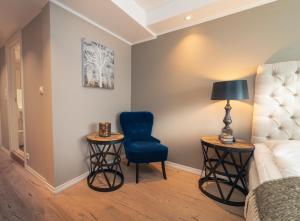 a living room with a blue chair and two tables at Ustedalen Hotel Geilo in Geilo