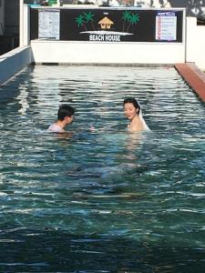 two people swimming in a swimming pool at the beachhouse in Dalaguete