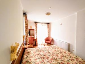 a bedroom with a bed and a desk and a window at Вила Цветелина, Комплекс Александриa in Dobrinishte