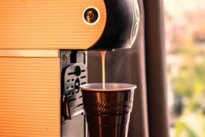 Hotel Condestable Iranzo في خاين: كوب من القهوة يخرج من آلة القهوة
