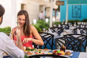 a woman sitting at a table with a plate of food at Sealife Family Resort Hotel in Antalya