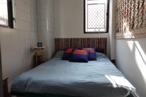 a bedroom with a bed with blue sheets and a window at Wontonmeen in Hong Kong