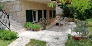 Casa con patio con mesa y algunas plantas en Vacation house dunja, en Runović