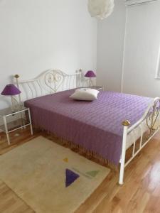 - une chambre avec un lit doté de draps violets et d'un tapis dans l'établissement Vacation house dunja, à Runović