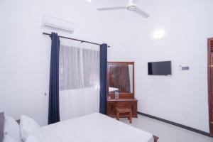 um quarto com uma cama, uma janela e uma secretária em StayAtRichmondHill - Free Air Conditioning WIFI em Galle