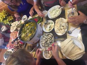 un grupo de personas de pie alrededor de una mesa llena de comida en Viet Duc Guest House, en Sa Pa