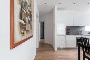 a kitchen and dining room with a painting on the wall at Montarina Apartment by Quokka 360 - lovely accommodation a few minutes from the centre in Lugano +10 photos