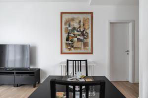 a living room with a table and chairs and a painting on the wall at Montarina Apartment by Quokka 360 - lovely accommodation a few minutes from the centre in Lugano