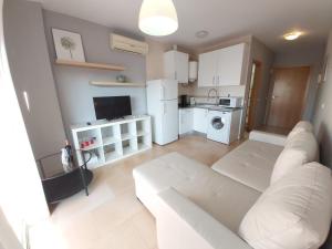 salon z białą kanapą i kuchnią w obiekcie Del Parque Flats Central w Maladze