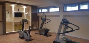 un gimnasio con cintas de correr y bicicletas estáticas en una habitación en JR Hotels Gigli Firenze, en Calenzano