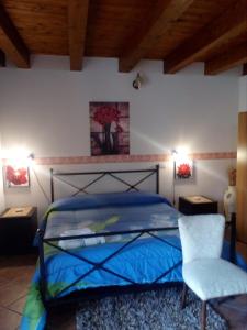 a bedroom with a blue bed and a chair at B&B Trinacria Modica in Modica