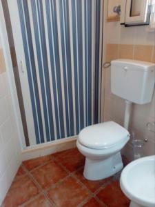 a bathroom with a toilet and a striped shower curtain at B&B Trinacria Modica in Modica