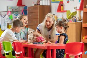 a woman and two children playing with blocks at a table at Sealife Family Resort Hotel in Antalya