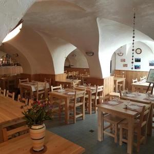 ein Restaurant mit Holztischen und -stühlen in einem Zimmer in der Unterkunft LE GÎTE LES MELEZES in Villar-dʼArène