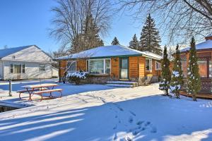 a log cabin with a picnic table in the snow at 4 Season, Waterfront Houghton Lake House with Dock! in Houghton Lake