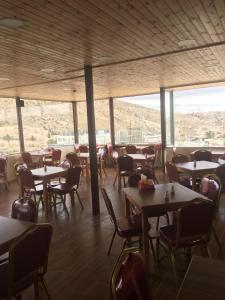 a dining room with tables and chairs and windows at Petra Cabin Inn Hostel&Resturant in Wadi Musa