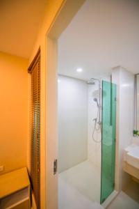 a bathroom with a shower with a glass door at Seven Seas Pattaya Poolside Room ห้องติดสระ in Jomtien Beach