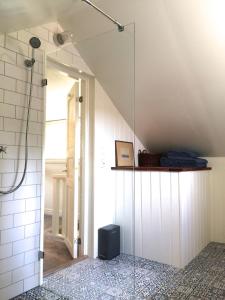 a bathroom with a glass walled shower with a mirror at The Fork and Shovel Farm in Bräcke