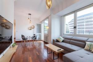 uma sala de estar com um sofá e uma mesa em Apartamento con vistas al Estadio San Mamés em Bilbao