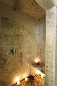 un baño con una pared de piedra con velas. en La Villa Bleue-Sidi Bou Said, en Sidi Bou Saïd