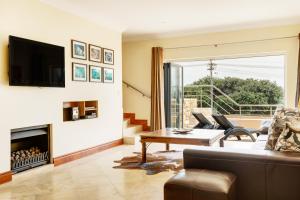a living room with a couch and a fireplace at Backup-Powered Camps Bay Beach Condo in Cape Town