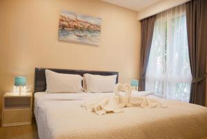 a bedroom with a bed with a towel on it at Seven Seas Pattaya Poolside Room ห้องติดสระ in Jomtien Beach +55 photos