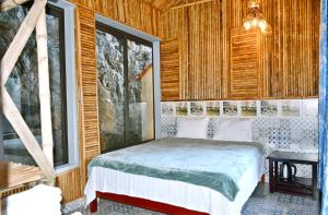 1 dormitorio con 1 cama en una habitación con ventanas en Tam Coc Lakeside Homestay, en Ninh Binh