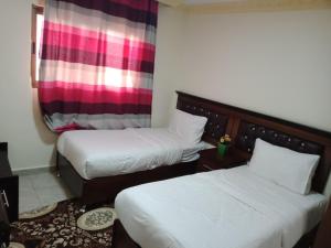 Un pat sau paturi într-o cameră la Petra Visitors Hotel