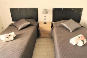 アルマカオ・デ・ペラにあるCasas & Papeis T-4のベッドルーム1室(隣り合わせのベッド2台付)