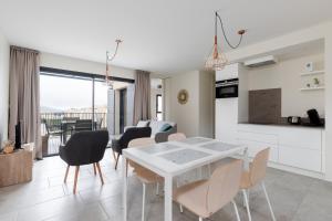 een keuken en eetkamer met een witte tafel en stoelen bij Les Cyclistes - Apartment i in Malaucène