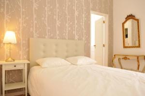 a bedroom with a white bed and a mirror at Baixa Cosy in Lisbon