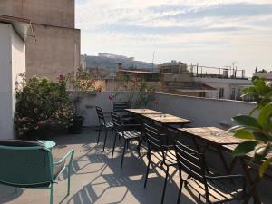 a patio with tables and chairs on a balcony at Boutique Central Apartments Acropolis View in Athens