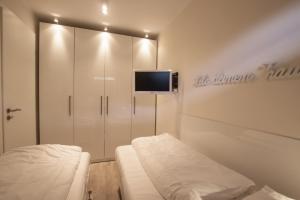 a room with a bed and a tv on a wall at Haus Dünenbake, Ferienwohnung Strandpeter Wohnung 13 in Sankt Peter-Ording