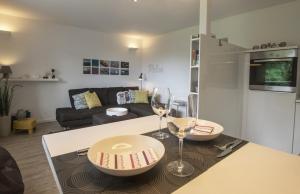 a kitchen and living room with a table with wine glasses at Haus Dünenbake, Ferienwohnung Strandpeter Wohnung 13 in Sankt Peter-Ording