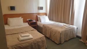 two beds in a hotel room with towels on them at Hotel Bellevue in Skopje