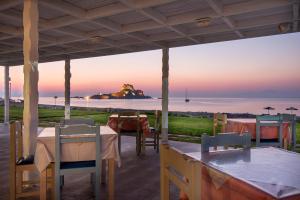 a patio with tables and chairs and a view of the ocean at Kordistos Hotel in Kefalos