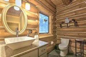 a bathroom with a sink and a mirror in a log cabin at Secluded Traverse City Retreat - Near Downtown! in Traverse City