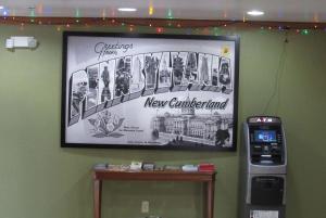 ein Bild hängt an einer Wand mit einem neuen Steckbrief in der Unterkunft Super 8 by Wyndham New Cumberland in New Cumberland