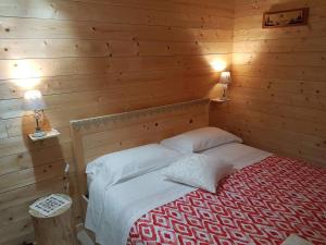 um quarto com uma cama numa parede de madeira em B&B ABETE BIANCO em Auronzo di Cadore